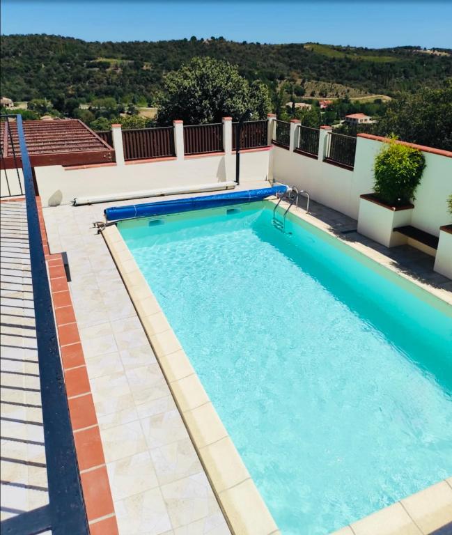 - une piscine sur le côté d'un bâtiment dans l'établissement Maison avec piscine VIVES 8 couchages 4 chambres, à Vivès