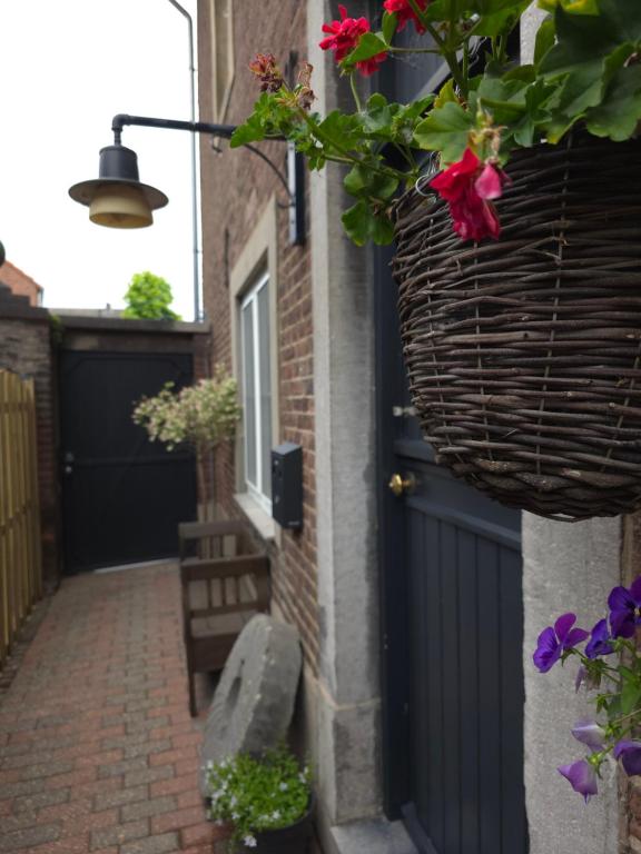 a house with a blue door and a basket of flowers at Boerderijwoning in Maastricht