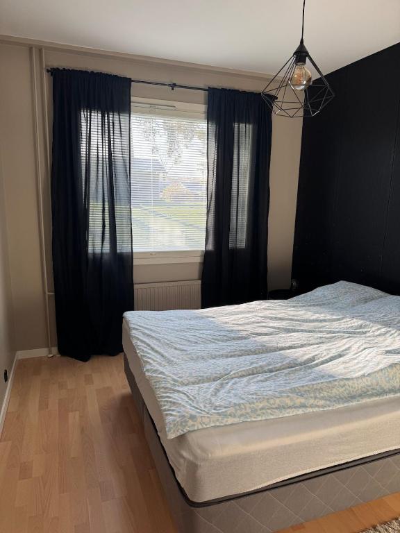a bedroom with a large bed and a window at Lägenhet Kaskö in Kaskö