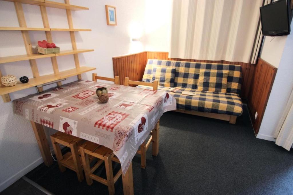 Cette petite chambre comprend une table et un canapé. dans l'établissement Résidence Joker - VAL THORENS STUDIO 3 PERS BELLE EXPOSITION MAE-7760, à Val Thorens