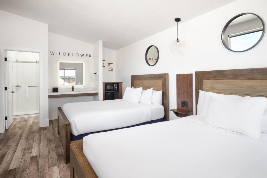 a hotel room with two beds and a mirror at Zion Wildflower Resort in Virgin