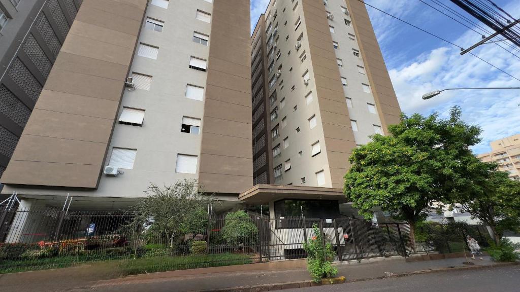 a tall building with a fence in front of it at Edifício Aquarius in Ribeirão Preto
