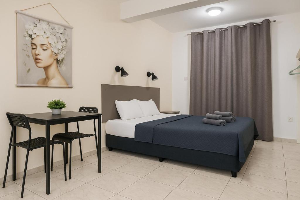a bedroom with a bed and a table and chair at Summer's Hotel Apartments in Ayia Napa