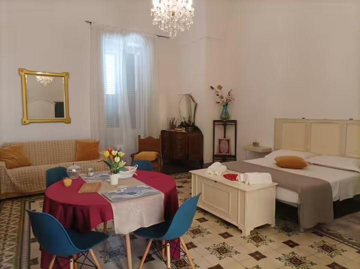 a bedroom with a bed and a table and chairs at Donna Michelina Rooms in Carmiano