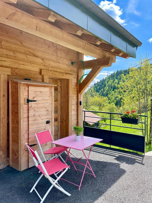 d'une terrasse avec une table rose et deux chaises. dans l'établissement Charmant appartement sous combles, neuf, aux Gets
