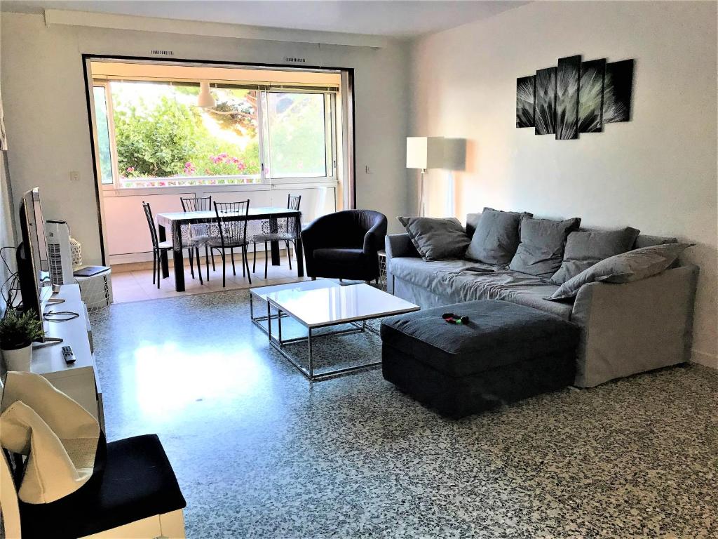 un salon avec un canapé et une table dans l'établissement Grand appartement proche mer avec WIFI, au Lavandou