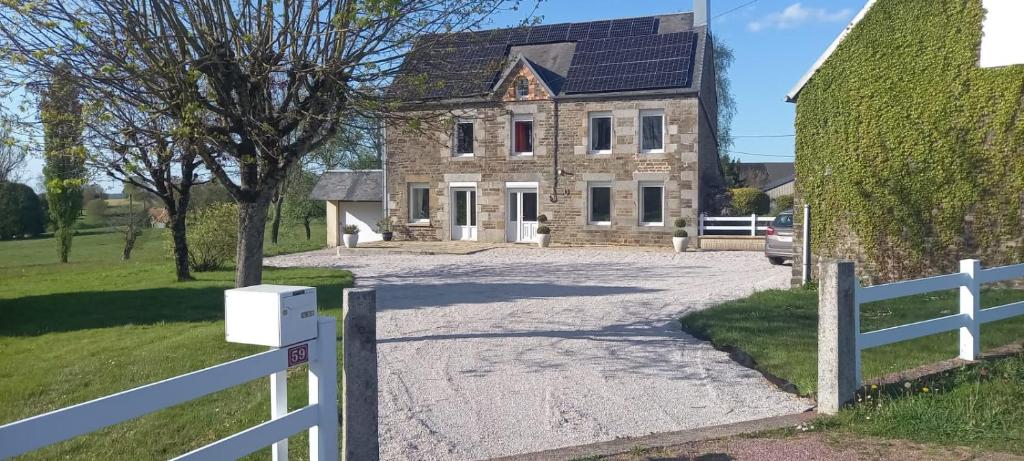 une maison avec une clôture blanche devant elle dans l'établissement L'Hôtel Coutances - Chambre d'Hôtes, à Fleury
