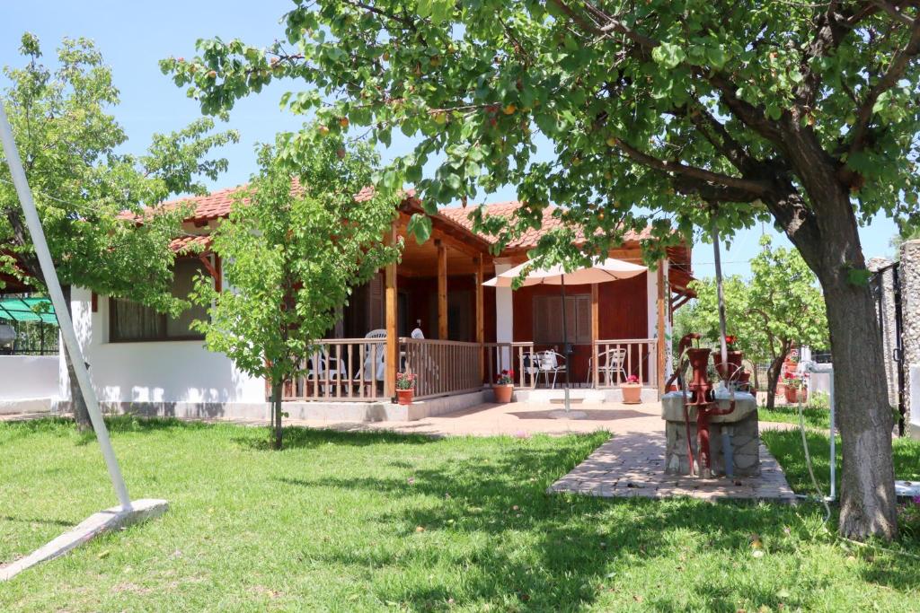a house with a tree in front of it at Charming Villa by the Sea in Nea Kalikratia