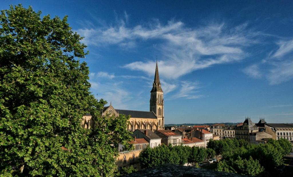 une grande église avec une cloche dans une ville dans l'établissement Hotel Le Gambetta, à Bergerac