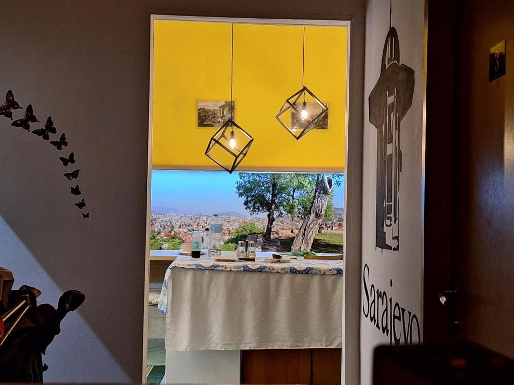 uma porta de sala de jantar com uma mesa e uma vista em At Mejdan Rooms em Saraievo