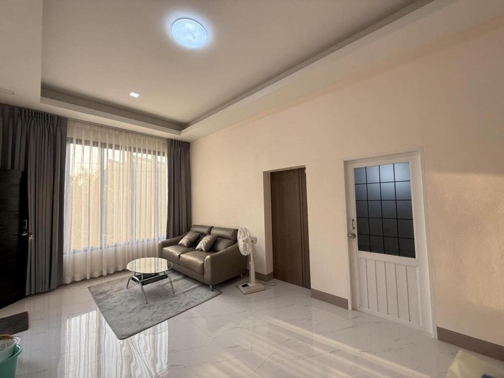 a living room with a couch and a window at Baan Santi in Koh Phangan in Thongsala