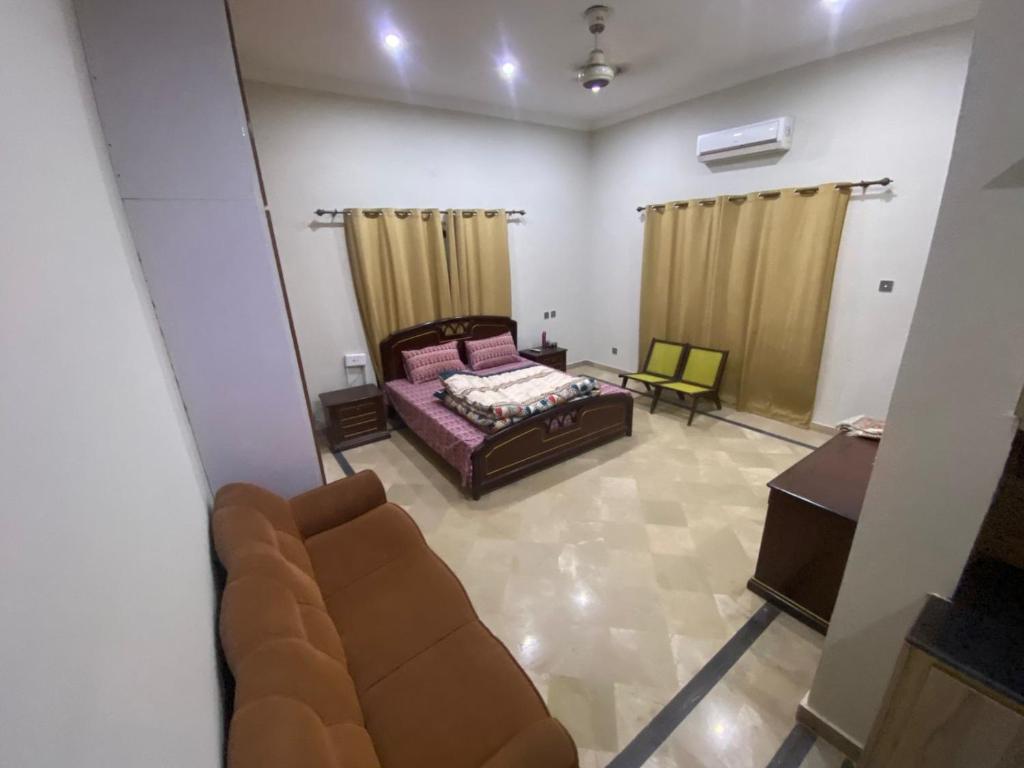 a living room with a bed and a couch at 20A Farmhouse in Islamabad