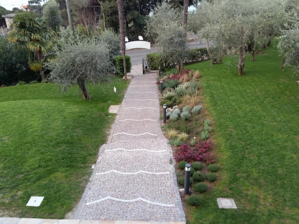a walkway in a garden with flowers and trees at Albergo Blueline in Tellaro
