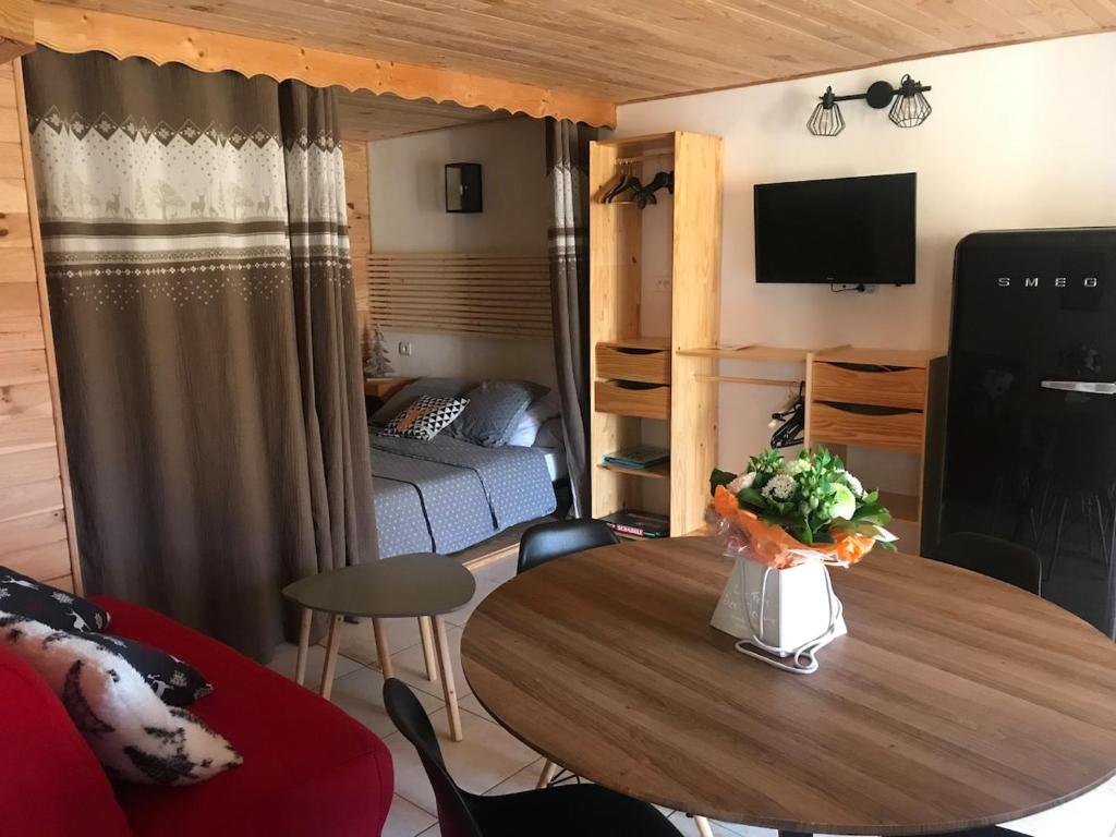 a living room with a table and a bedroom at Les chardons bleus in Formiguères