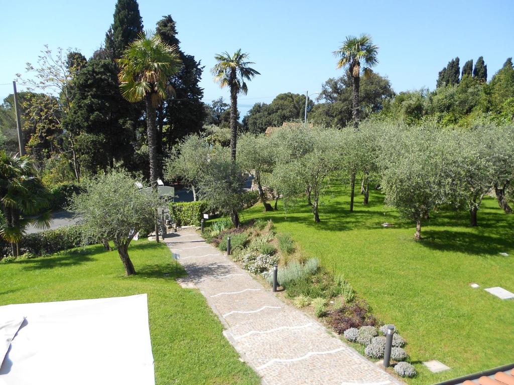 a garden with olive trees and a pathway at Albergo Blueline in Tellaro