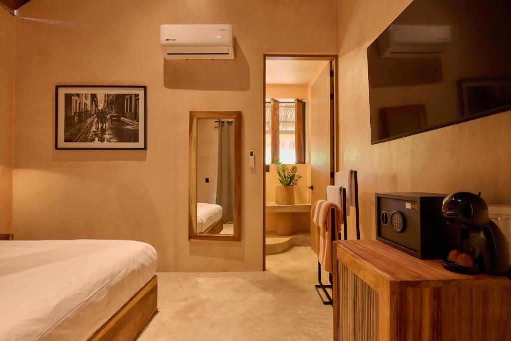 a bedroom with a bed and a tv and a mirror at Pan Beach in Brisas de Zicatela