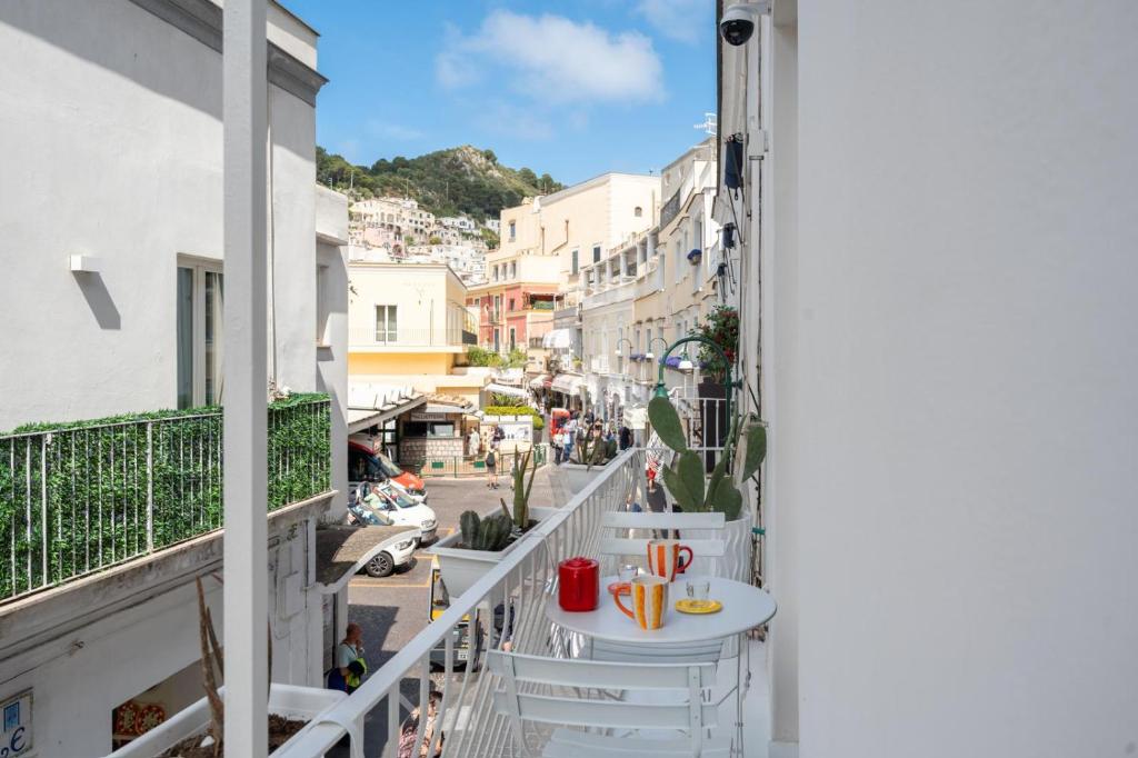 - un balcon avec une table et des chaises dans une rue dans l'établissement Casina Caprese, à Capri