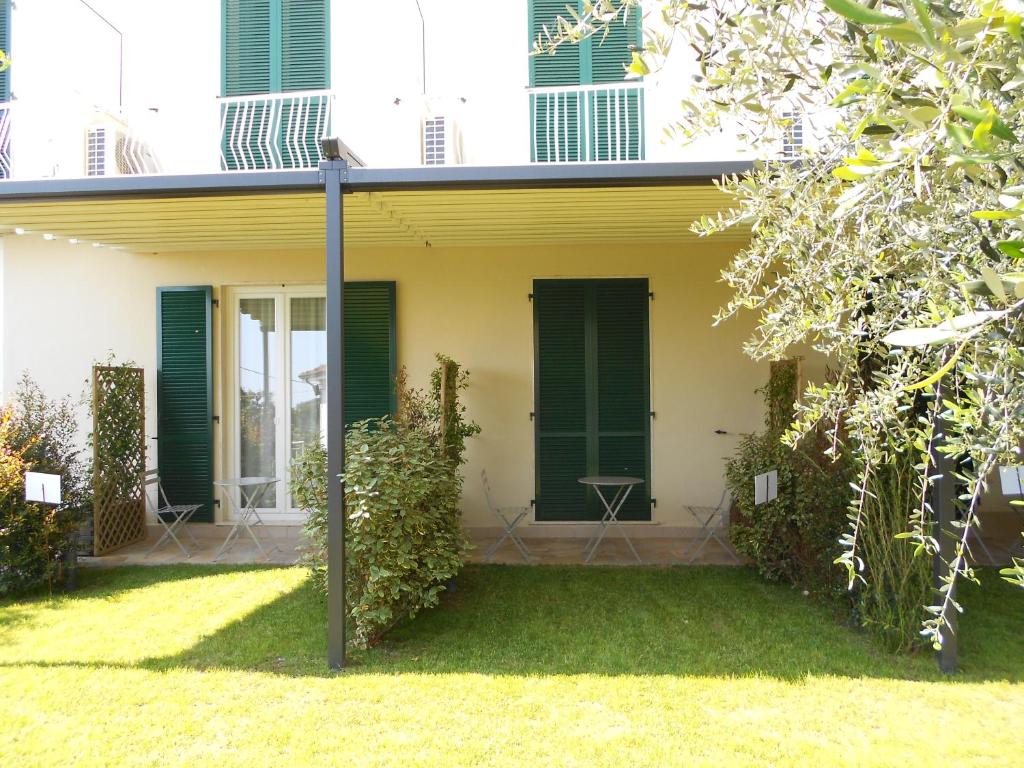 a house with green shutters and a yard at Albergo Blueline in Tellaro