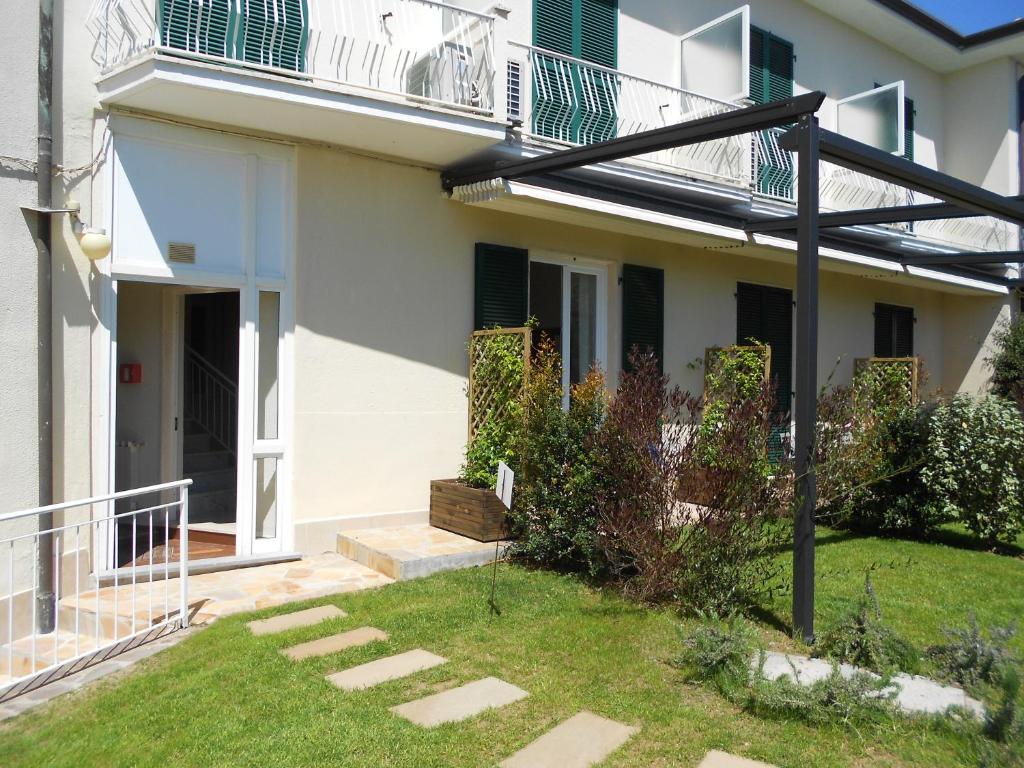 a white house with a balcony and a yard at Albergo Blueline in Tellaro