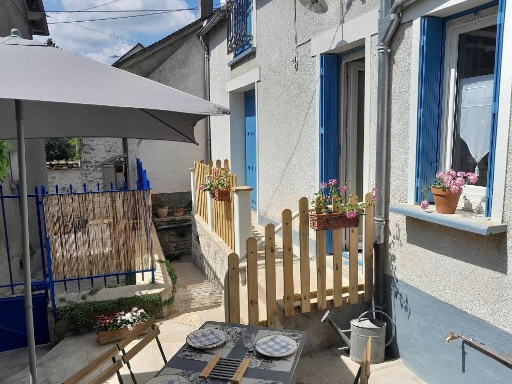a patio with a table and an umbrella at La maison d'à côté in Montigny-sur-Loing