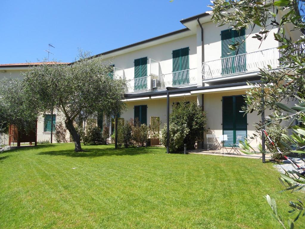 a large white building with a green yard at Albergo Blueline in Tellaro