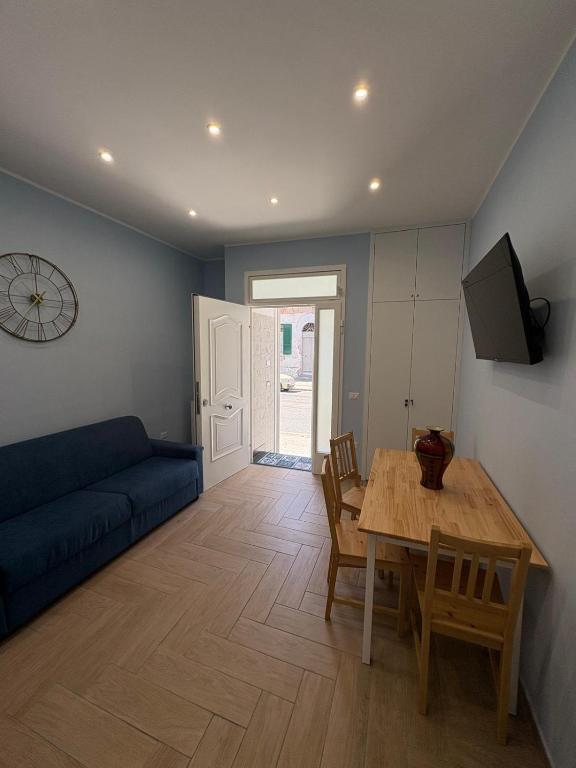 a living room with a blue couch and a table at Don Mimì Casa Vacanza in Torre del Greco