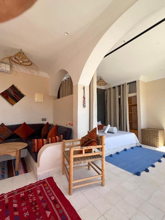 a bedroom with a bed and a couch at SurfAppart Morocco in Tamraght Ouzdar