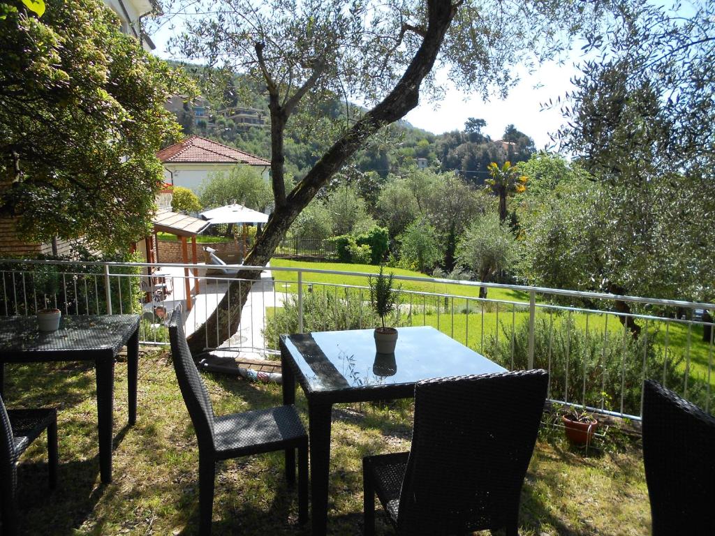 a patio with two tables and chairs and a fence at Albergo Blueline in Tellaro