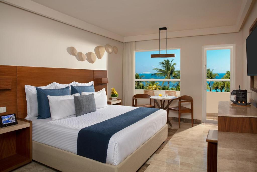 Una habitación de hotel con una cama y vista al océano. en Dreams Sands Cancun Resort & Spa, en Cancún
