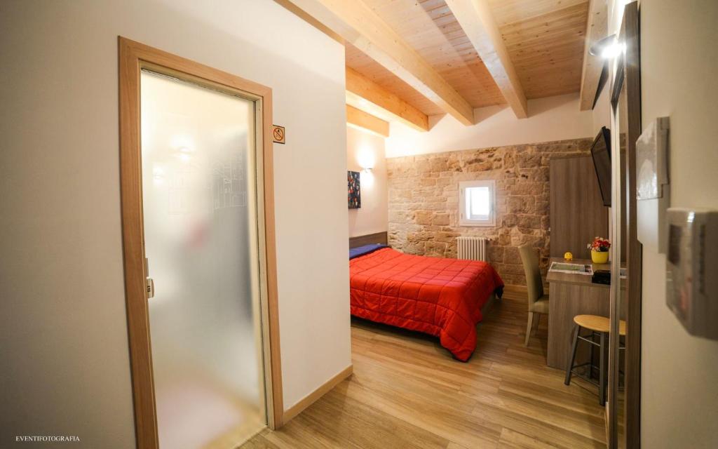 ein Schlafzimmer mit einem roten Bett in einem Zimmer in der Unterkunft B&B Il Campanile in Barletta