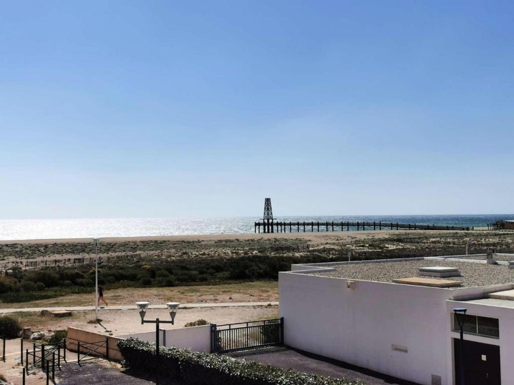 - une vue sur la plage avec une jetée en arrière-plan dans l'établissement Résidence Belle Plage - 2 Pièces 4 couchages PORT LEUCATE. Réf: 3BP_36D MAE-8313, à Leucate