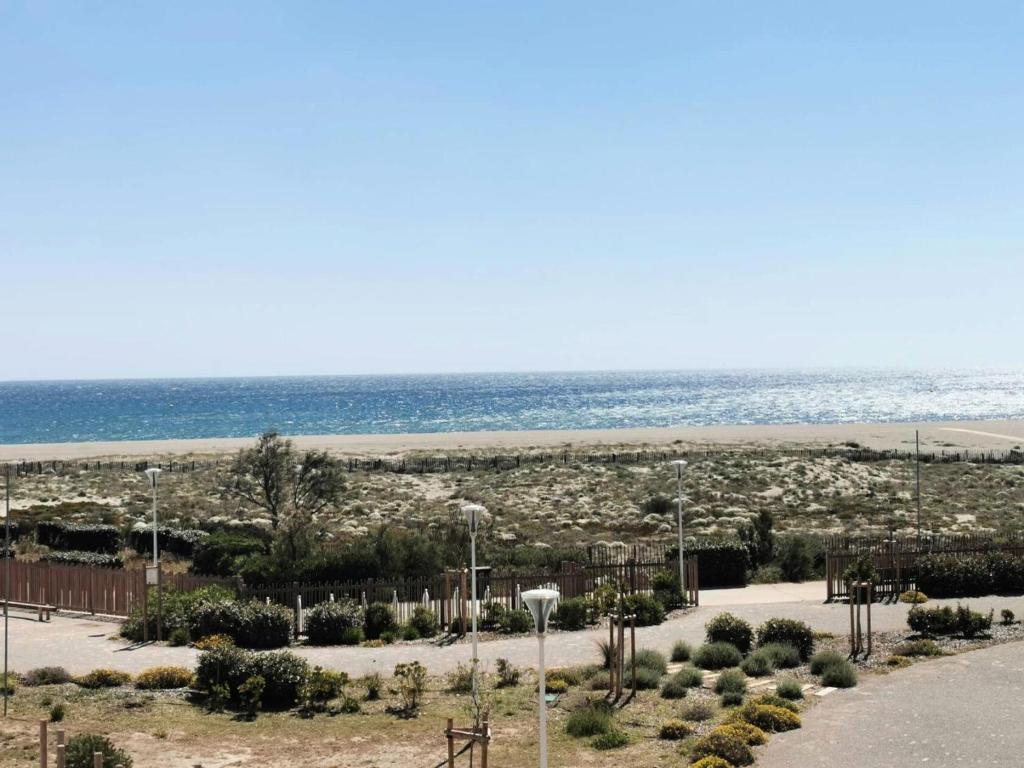 - une vue sur la plage et l'océan en arrière-plan dans l'établissement Résidence Les Nefs Des Sables - STUDIO AVEC LOGGIA 5 couchages PORT LEUCATE. Réf: 2NEF_21K3 MAE-8323, à Leucate
