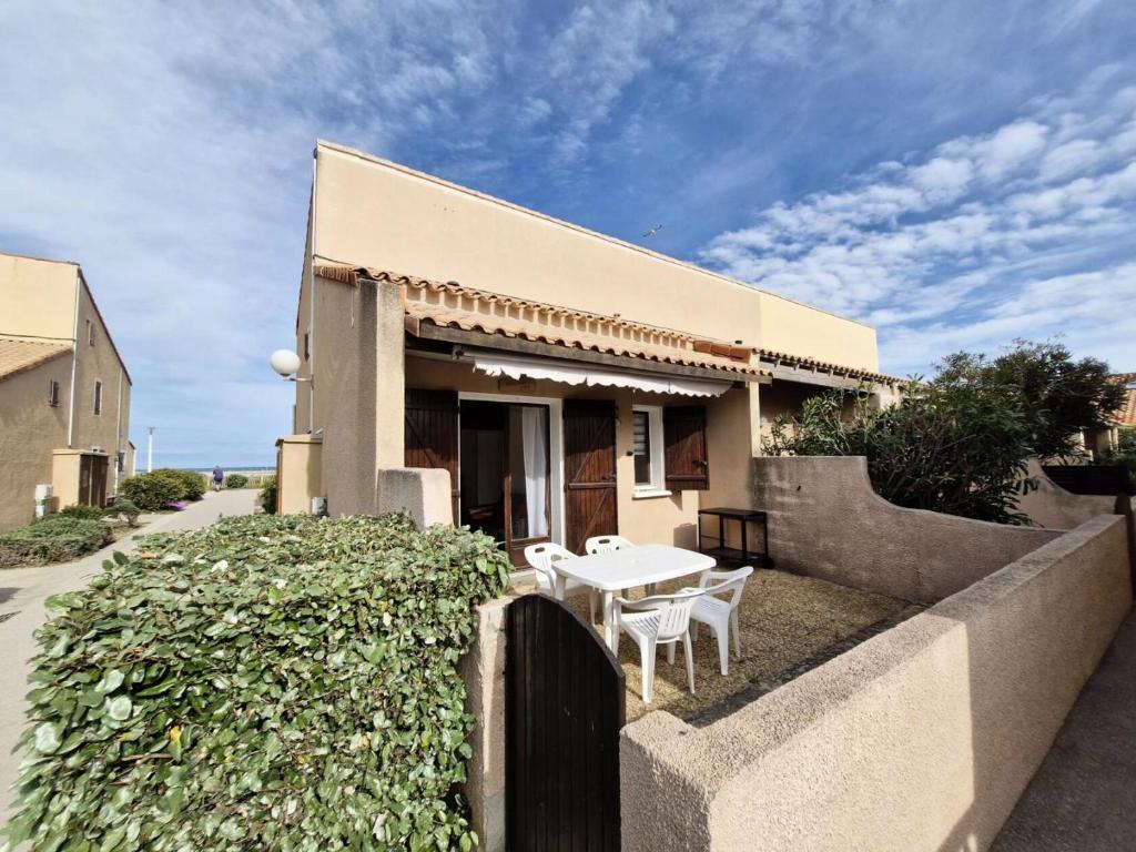 une maison avec une table et des chaises devant dans l'établissement Résidence Grande Bleue - VILLA T2 MEZZANINE 6 couchages PORT LEUCATE. Réf: 3GB_195 MAE-8333, à Leucate