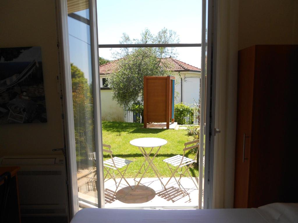 a bedroom with a door open to a patio with a table at Albergo Blueline in Tellaro