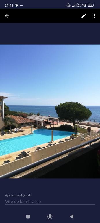 - une vue sur la piscine et l'océan en arrière-plan dans l'établissement appartement bord de Mer, à Santa-Lucia-di-Moriani