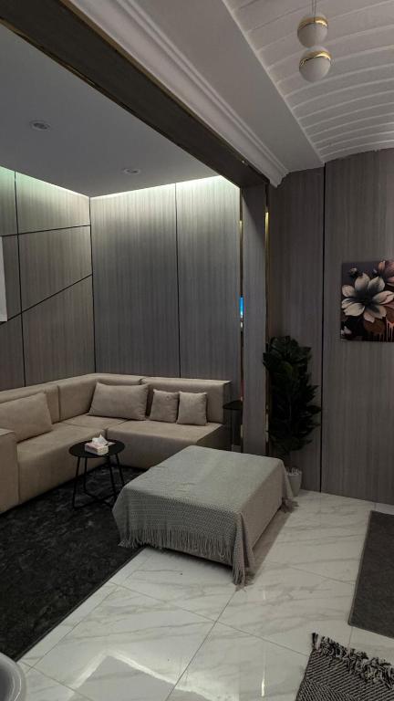 un salon avec un canapé et une table dans l'établissement شقه انيقة بغرفه وصاله مدخل خاص, à ‘Aryam