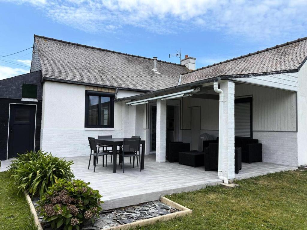 une maison avec une terrasse avec une table et des chaises dans l'établissement Résidence G104-ile Grande - Les Dunes maison avec jardin clos à Ile Grande MAE-3434, à Pleumeur-Bodou