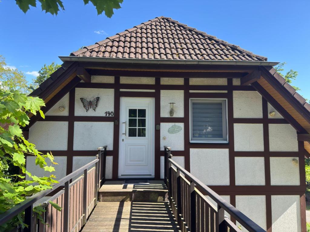 ein Haus mit einer Veranda und einer weißen Tür in der Unterkunft Apartment in Kellerwald near Edersee Lake in Frankenau