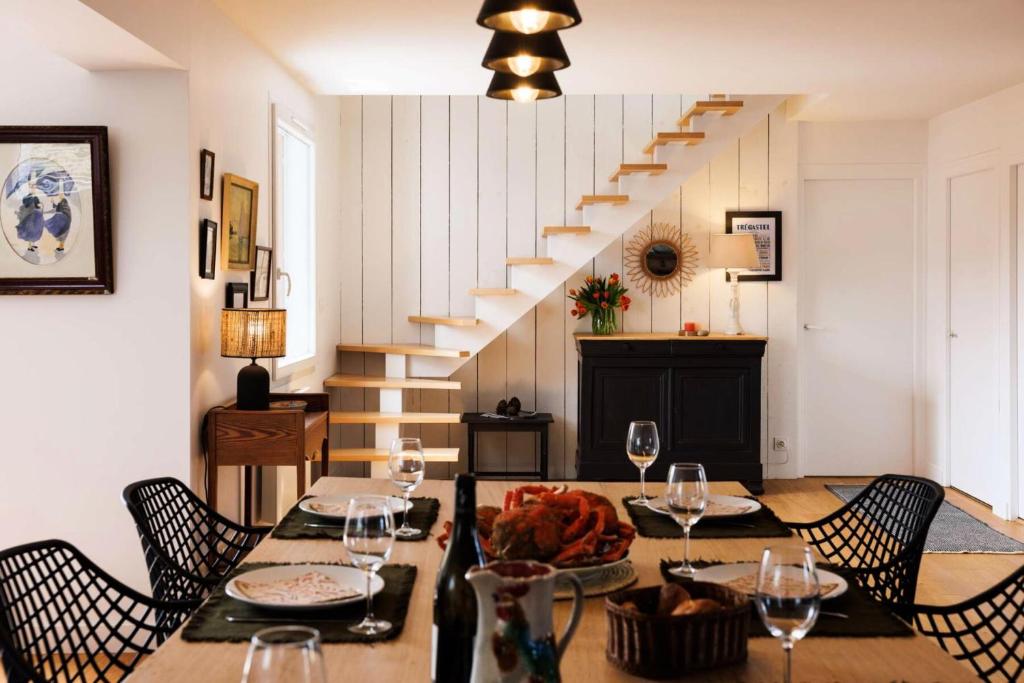 une salle à manger avec une table et des verres à vin dans l'établissement Résidence M08-4p-tregastel - Maison à 300 m. de la plage de Tourony MAE-2043, à Trégastel
