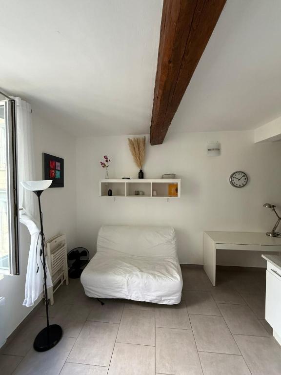 une chambre avec un lit blanc dans une pièce dans l'établissement Les CARMES 1 G pour 2 pers - joli meublé et Wi-Fi, à Avignon