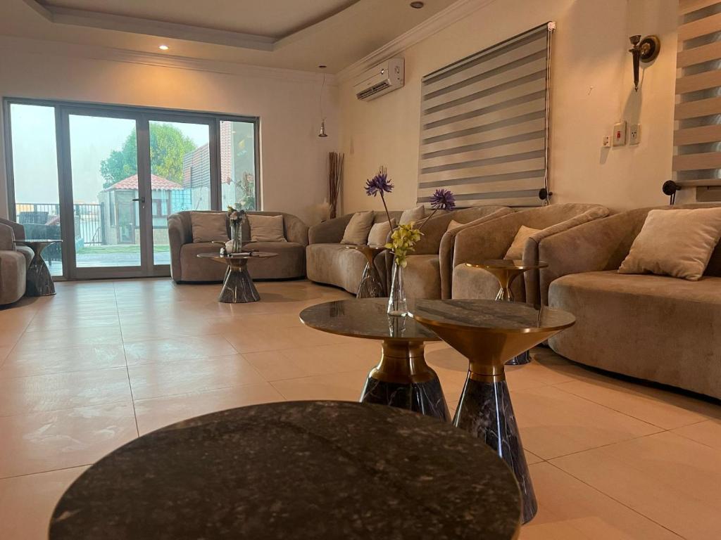 a living room with couches and tables at شاليه موج البحري بمسبح وشاطئ خاص in Half Moon Bay