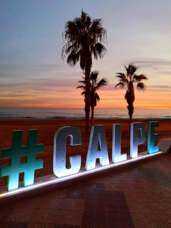 a sign for the beach with palm trees in the background at Paradis Calpe in Calpe