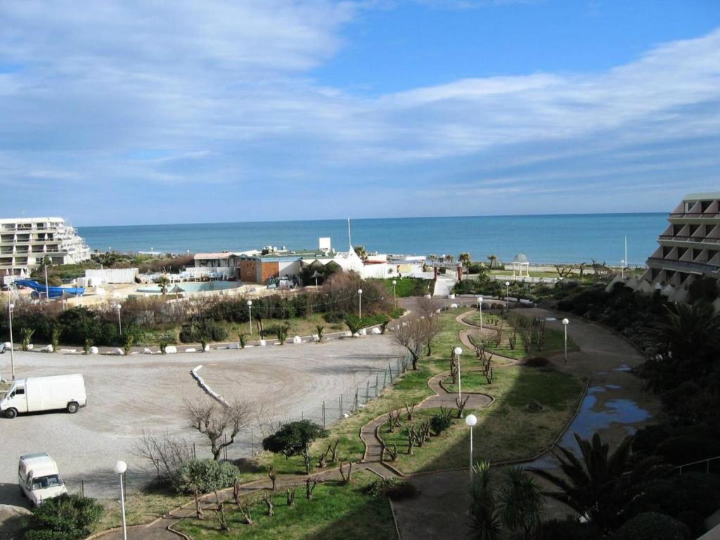 - une vue sur un parking avec l'océan en arrière-plan dans l'établissement Résidence Héliopolis Bâtiment E - studio 2 Pers. Héliopolis Bât. E MAE-4474, au Cap d'Agde