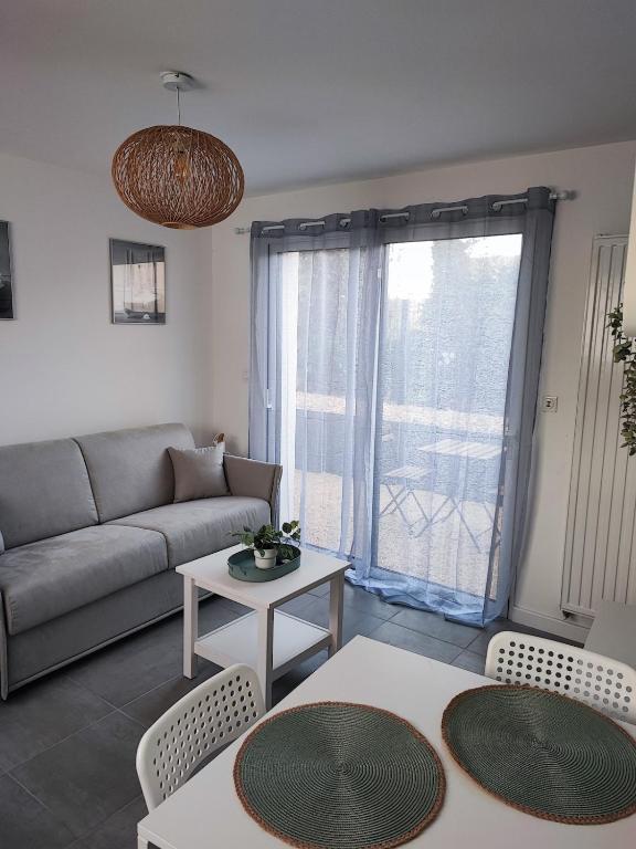 un salon avec un canapé et une table dans l'établissement Le cocon, à Bréal-sous-Montfort