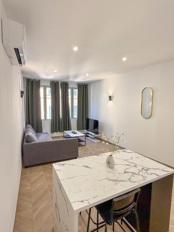 un salon avec une table et un canapé dans l'établissement T1 luxe Hyper centre 100 m du port Clim wifi fibre, à Toulon