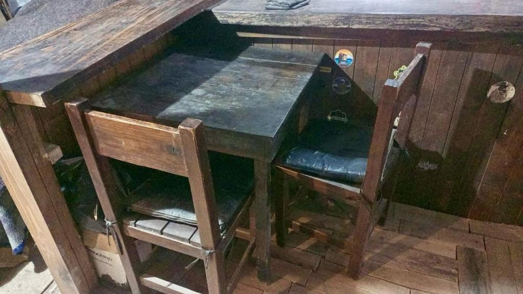 a wooden desk with two chairs and a wooden table with a wooden table at Cabaña el ojo de Horus el chalten santa cruz in El Chalten