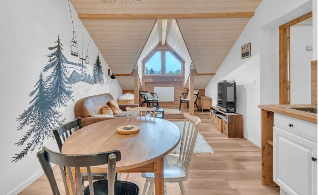 a kitchen and living room with a table and chairs at Appartement au pied des pistes Féclaz-Revard in Les Déserts