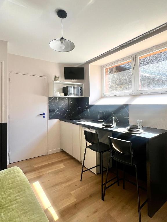 une cuisine avec une table et des chaises dans une pièce dans l'établissement Studio en rdc - hyper centre Dol de Bretagne, à Dol-de-Bretagne