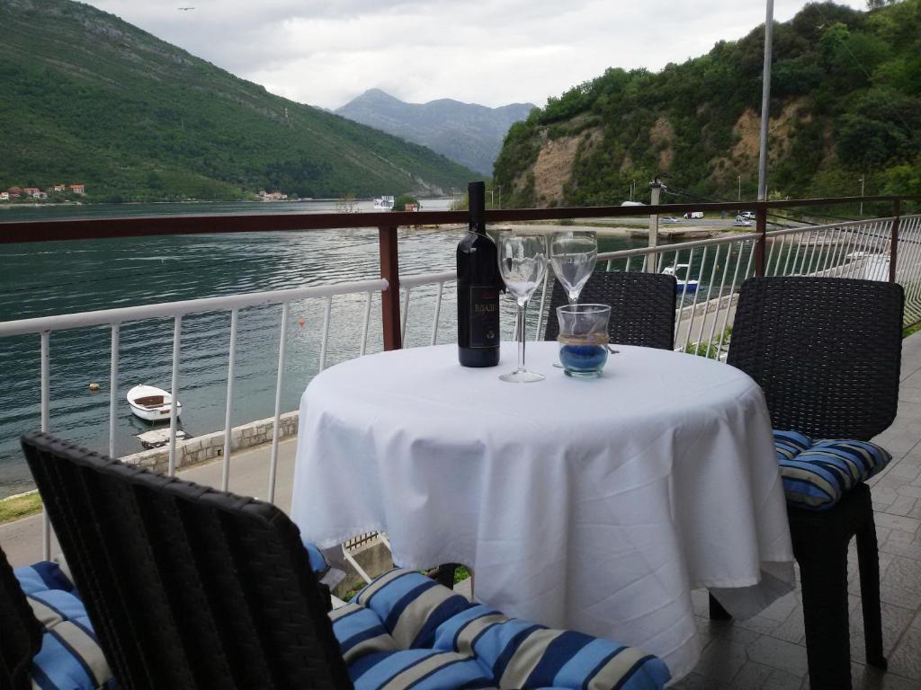 a table with a bottle of wine and glasses on it at Apartmani Ivana in Tivat