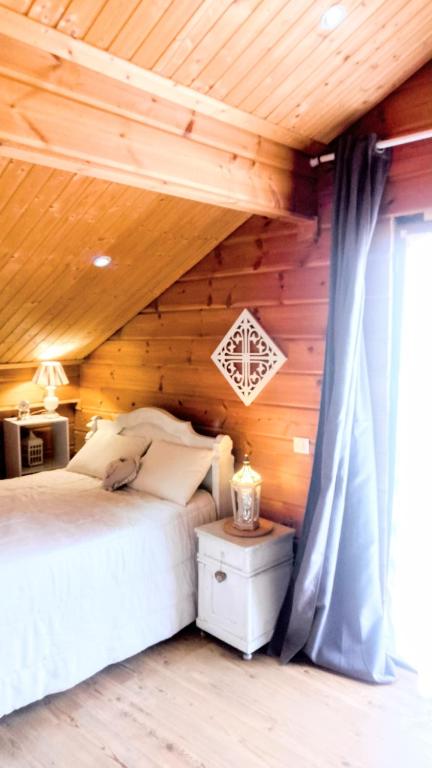 une chambre avec un lit et un plafond en bois dans l'établissement studio nature & détente jacuzzi, à Puessans